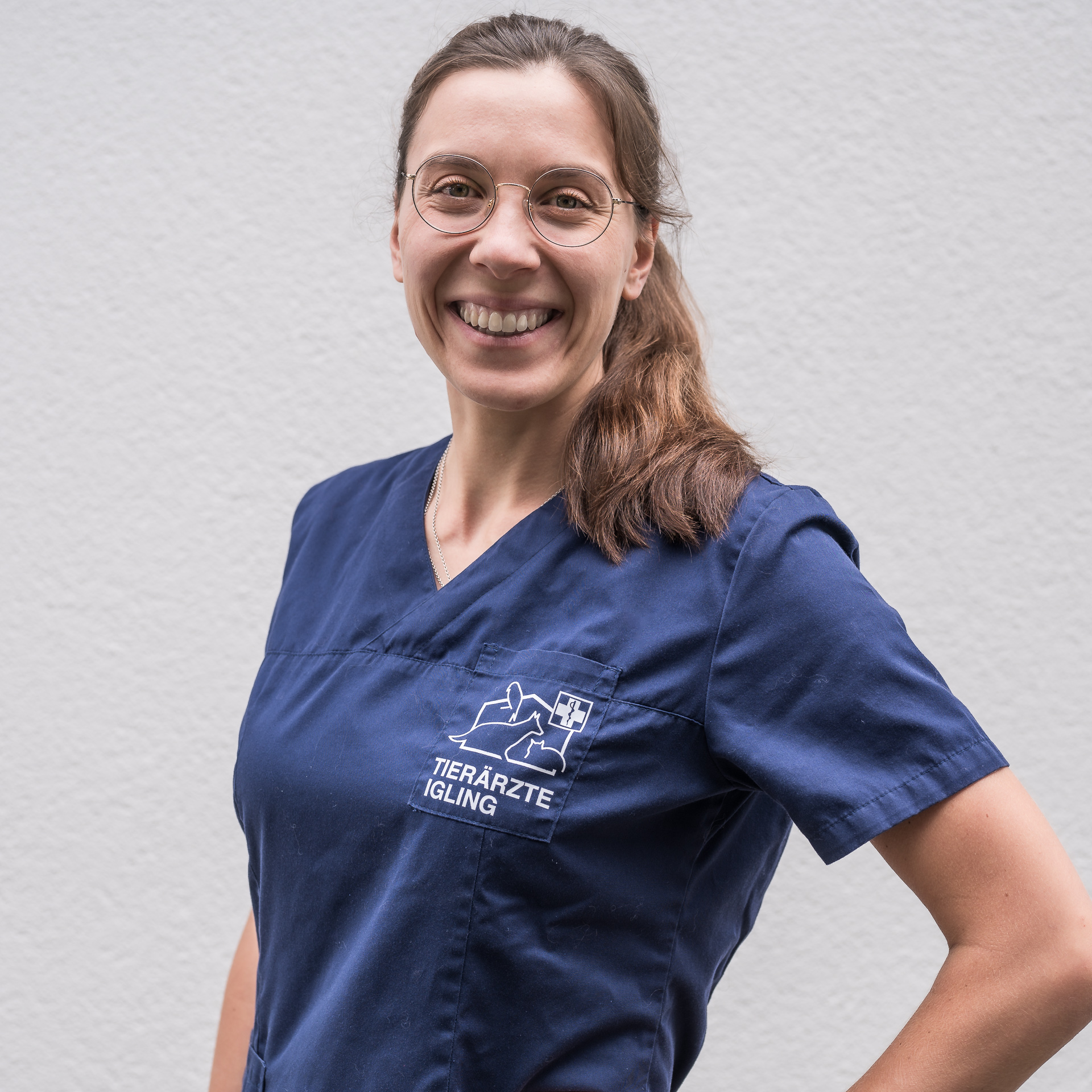 Tierärztin Amelie Eschenbach steht nett lächelnd vor einem hellen Hintergrund.