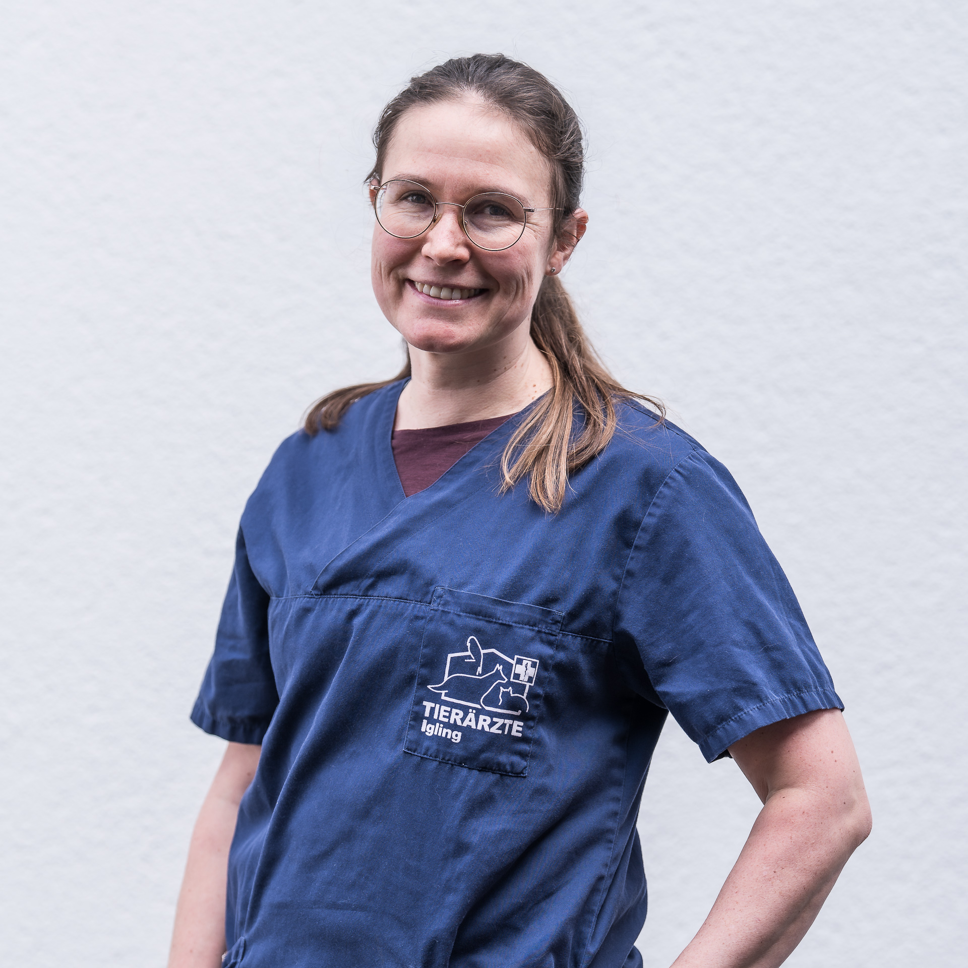 Tierärztin Dr. Franziska Rauch steht vor hellem Hintergrund und schaut nett lächelnd in die Kamera.